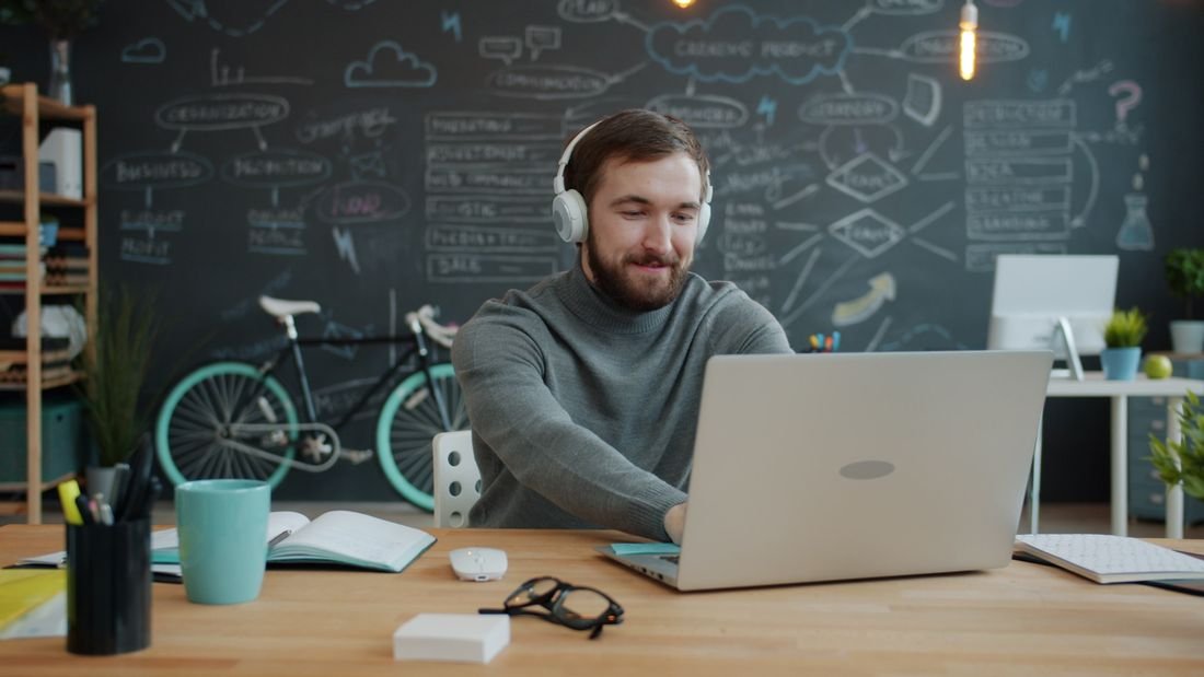 Writer at a laptop in a studio with a chalkboard wall